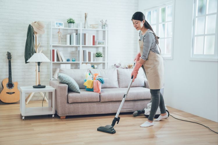 mulher limpando a casa com aspirador de pó