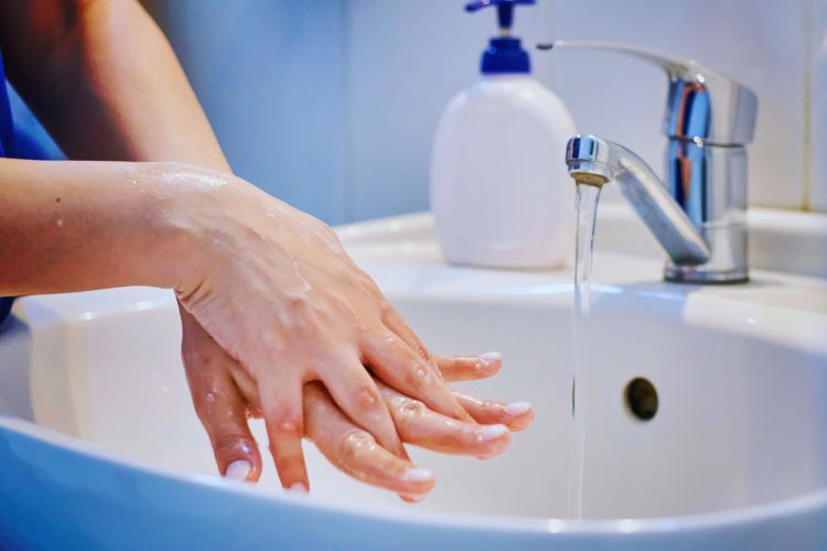 mulher limpando as mãos na água