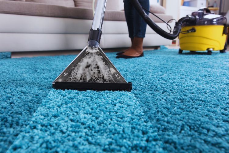 pessoa limpando tapete azul