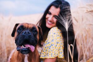 cachorro boxer com mulher no campo